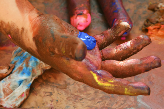Hands of a child in paint playing on the Sun in the time of isolation background. 