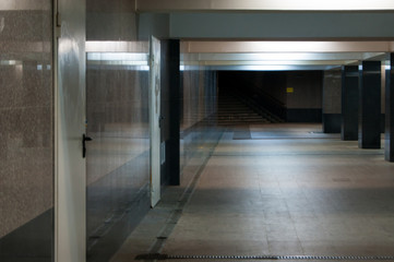 An empty underpass in marble. Columns and light create rhythm