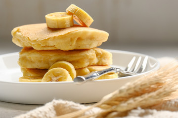 Delicious pancake with banana slices served on wooden table