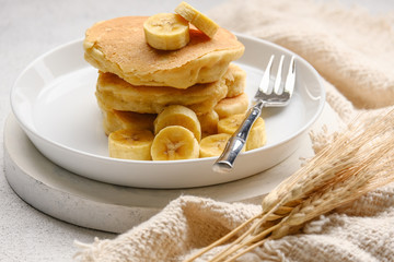 Delicious pancake with banana slices served on wooden table