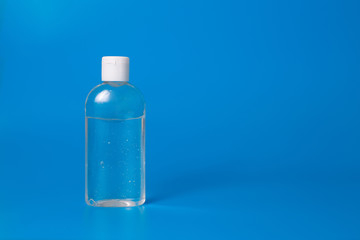 Blue background with a bottle with antibacterial hand gel sanitizer