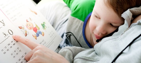 Mother teaches child to read. Home education