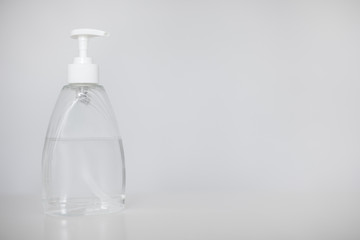 hand hygiene or disinfection concept - bottle of sanitizer gel or liquid soap over white