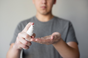 hand hygiene or disinfection concept - man washing hands with sanitizer spray