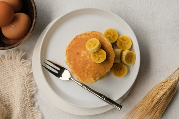 Delicious pancake with banana slices served on wooden table