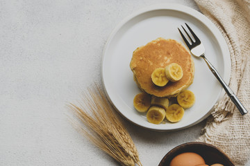 Delicious pancake with banana slices served on wooden table