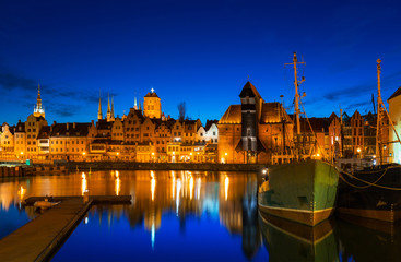 Naklejka premium Old town in Gdansk with historical port crane over Motlawa river at night, Poland.