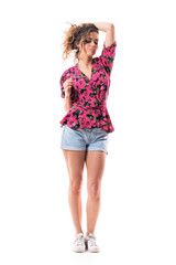 Cocky attitude confident sexy young woman holding hair in bun looking down and thinking. Full body isolated on white background. 