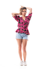 Cute uncertain thinking young woman holding curly hair making hairstyle looking up. Full body isolated on white background. 