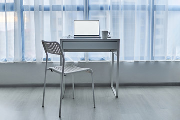 Computer desk on an empty workplace in a white interior. Remote work at home. Home office. Mockup