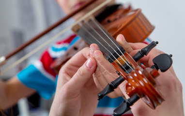 Music school: teacher teaches a child to play the violin