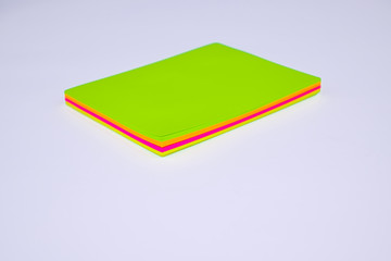 Top view of a stack of different colored paper sticky notes on top of a desk