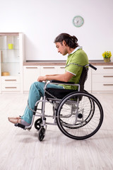 Young male invalid in wheel-chair suffering at home