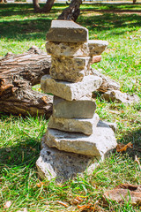 Fototapeta premium The stones lie rug on each other. A pillar of stones. Stone post on the grass.