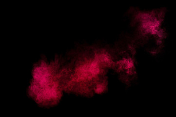 Red and pink powder explosion on black background. Colored powder cloud. Colorful dust explode. Paint Holi.