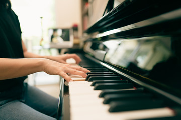 Obraz premium Scene of piano lessons online training or E-class learning while Coronavirus spread out or covid-19 crisis situation, vlog or teacher make online piano lesson to teach students pupils learn from home.