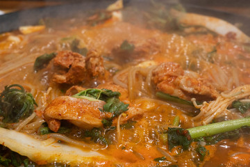 Close up image of Chicken being boiled on a hot pot with vegetables. Korean spicy chicken stir fry, Dak Galbi.