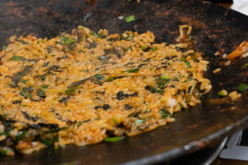 Korean style spicy fried rice with seaweed and vegetables cooked on a large frying pan.