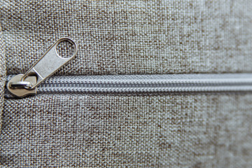  gray zipper for clothes on a gray texture background © Andrey