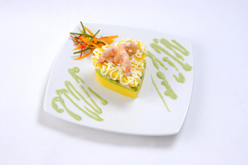 Peruvian food: filled potato or causa rellena with shrimps served on a white plate with white background