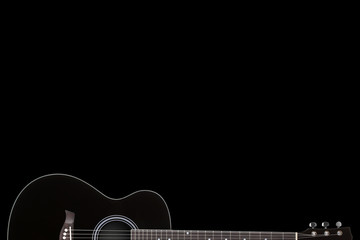 Black guitar on black background with copy space