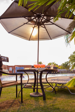 Mesa con paraguas, tragos y sol en la piscina
