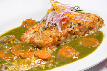 Peruvian food: closeup of a Tacu-tacu with Asian style lomo saltado served on a white plate