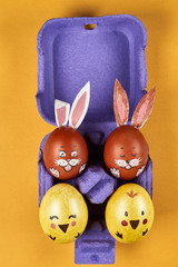 colorful easter eggs in an egg tray on a yellow background