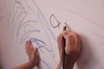 Close up of child hand drawing on wall