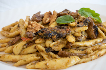 Cortecce, homemade Italian pasta with mushrooms, cherry tomatoes and walnuts. An excellent dish made in Italy