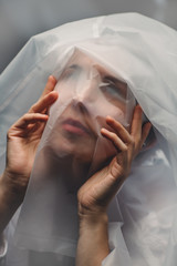 The female face is covered with white translucent cellophane. Quarantine.