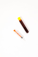syringe for injection and test tube with blood, pills on a white background