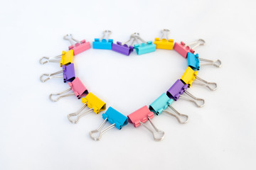 Heart of multicolored paper clips on a white background