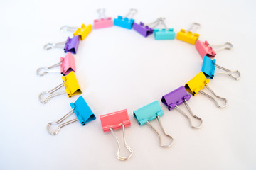 Heart of multicolored paper clips on a white background