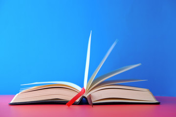 Opened empty book on blue background, space for text.