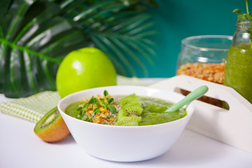 Fresh blended green smoothie bowl with muesli and chia seeds. Health and detox concept.