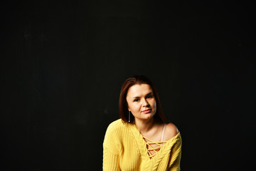 beautiful girl in a yellow jacket on a black background