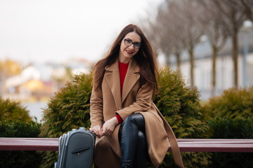 Business woman standing near airport with luggage during business trip