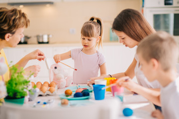Obraz na płótnie Canvas Family Easter Decoration Painting Eggs Mom with three kids