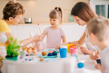 Obraz na płótnie Canvas Family Easter Decoration Painting Eggs Mom with three kids