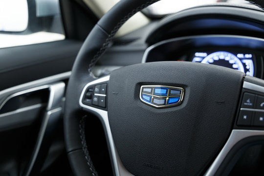 Samara / Russia - 03.16.2019: The Close-up Geely logo. Multimedia leather steering wheel in a modern expensive car Geely Atlas. Modern car interior details. Car detailing