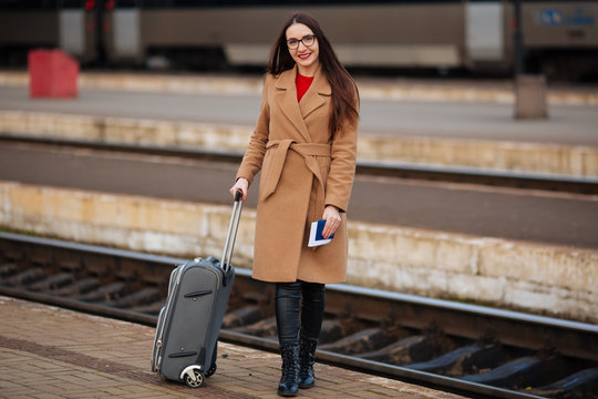 woman in coat with suitcase. Travel concept