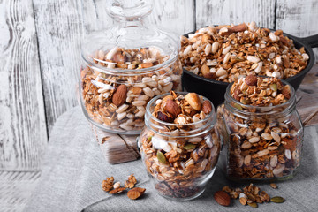 Homemade granola with different nuts and seeds in glass jars
