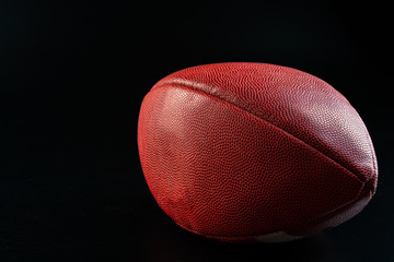 American foottball ball on dark background close up. American football concept