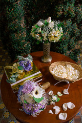 Obraz na płótnie Canvas Mesa de madera con ramo de flores y petalos blanco pared de hiedra
