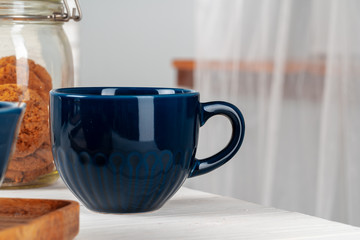 Classic blue empty ceramic tea cup on kitchen table close up