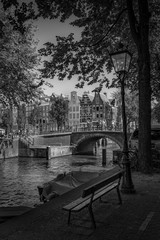 A view of buildings bridge and boats along the Amsterdam canal.