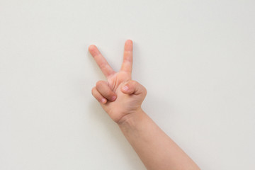 Top view of child hand showing two fingers as number two on the white background