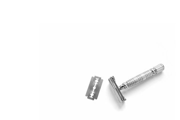 T - shaped metal razor with interchangeable blades. Butterfly safety razor. The blade is inserted inside and clamped on both sides. Zero waste. Eco-friendly consumption. White background. Minimalism