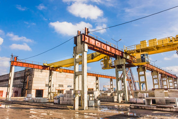 Fototapeta na wymiar Industrial area, site with bridge crane and concrete blocks, production background